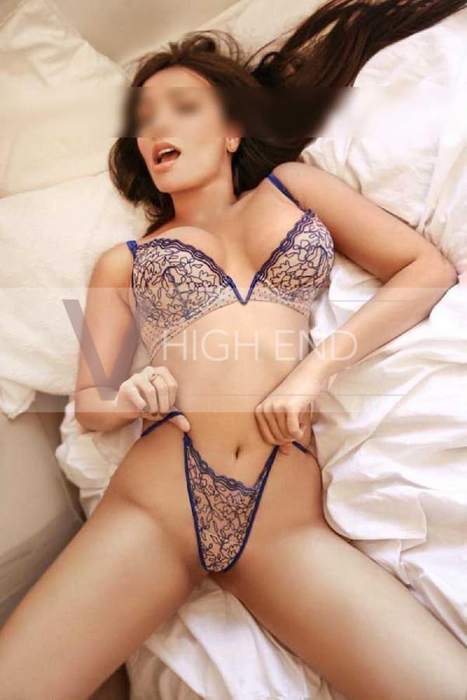 London escort Juli is pulling her panties up is seductive pose on a bed